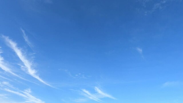 white cirrus clouds in sunny clear blue sky