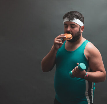 a fat man eating a hamburger while doing weights.
willpower.