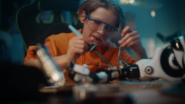 Smart Young Teenage Schoolboy is Studying Electronics and Soldering Wires and Circuit Boards in His Science Hobby Robotics Project. Kid is Working on a Robot in His Room. Education Concept.