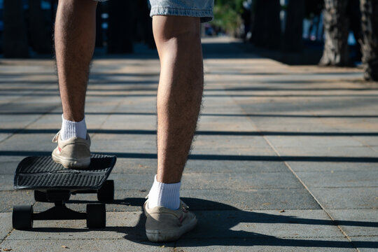 close up Man teennager leg wearing sport shoes  playing surf skate on the road oudoor in the morning. Relax and enjoy extreme surfskate on summer holiday at the beach.