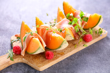 melon slice with ham and raspberry