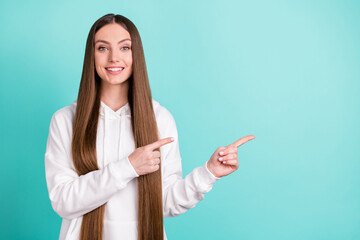 Portrait of attractive cheerful girl demonstrating copy empty place space ad idea isolated over bright teal turquoise color background