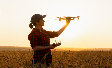 Woman farmer with drone on a wheat field. Smart farming and precision agriculture