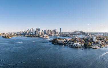 Obraz premium Stunning wide angle panoramic aerial drone view of the City of Sydney, Australia skyline with Harbour Bridge and Kirribilli suburb in foreground. Photo shot in May 2021, showing newest skyscrapers.