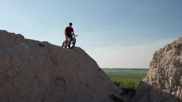 silhouette of older man on a fat mountain bike at a cliff overlooking a prairie - Pawnee National Grassland in Colorado