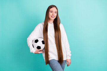 Photo of pretty charming young lady wear white sweatshirt holding football ball smiling isolated turquioise color background