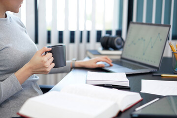 Office work concept a female secretary holding a cup of coffee relaxingly doing her job