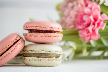 Fototapeta na wymiar colorful macarons with flowers and white background