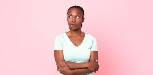 afro black adult woman doubting or thinking, biting lip and feeling insecure and nervous, looking...