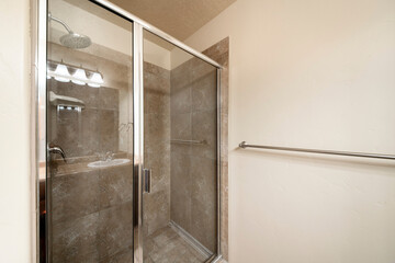 Shower stall inside a bathroom with glass panel and metal frames