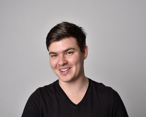 Close up head and shoulders portrait of a brunette. young man with a variety of expressive facial expressions. Isolated on a light grey studio background.