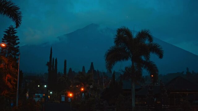 street at night in the dark with clouds and blue skies in the background covering the volcano