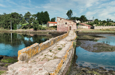 Estrecho puente de piedra y molino de las mareas de A Seca en la localidad de Cambados, España