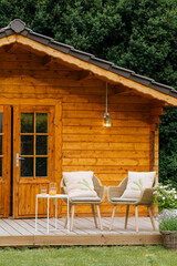 2 woven garden chairs outside in the garden with lots of trees and flowers. Rest in the garden. Cottage with garden. Vacation at home 