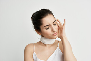 woman in white t-shirt bandage on the neck light background