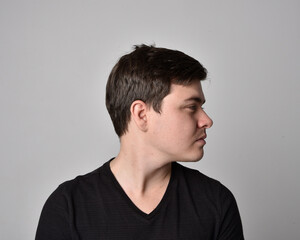 Fototapeta premium Close up head and shoulders portrait of a brunette. young man with a variety of expressive facial expressions. Isolated on a light grey studio background.