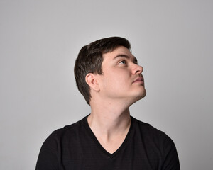Obraz premium Close up head and shoulders portrait of a brunette. young man with a variety of expressive facial expressions. Isolated on a light grey studio background.