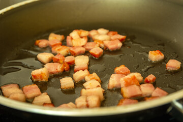 Bacon fried in oil in a pan