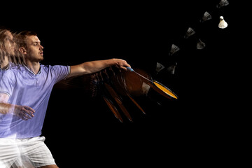 Spectacular trajectory of movement. One young male badminton player, shuttler training isolated on...