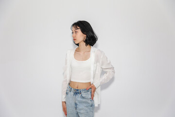 Young cute teen girl in jeans and shirt on a white background