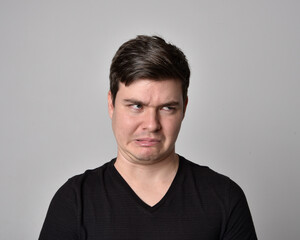 Obraz premium Close up head and shoulders portrait of a brunette. young man with a variety of expressive facial expressions. Isolated on a light grey studio background.
