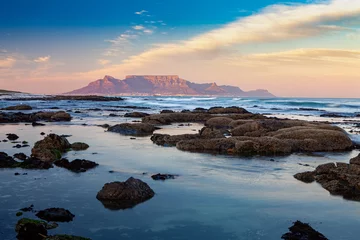 Crédence de cuisine en verre imprimé Montagne de la Table scenic view of table mountain in capetown south africa from bloubergstrand at sunset with sea and rocks in foreground