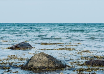 Fototapeta na wymiar small rocks in baltic sea against sky, nature and ocean background