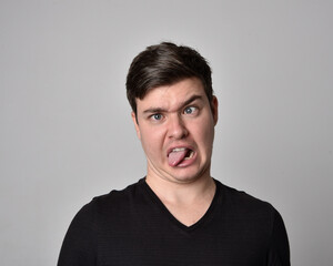 Obraz premium Close up head and shoulders portrait of a brunette. young man with a variety of expressive facial expressions. Isolated on a light grey studio background.