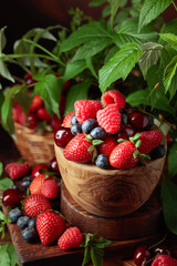 Assorted fresh berries with leaves.