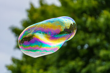 Releasing huge colorful soap bubbles in the open air
