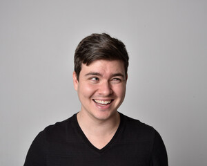 Close up head and shoulders portrait of a brunette. young man with a variety of expressive facial expressions. Isolated on a light grey studio background.