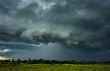 Extreme thunderstorm shelf cloud moving over fields, climate change concept
