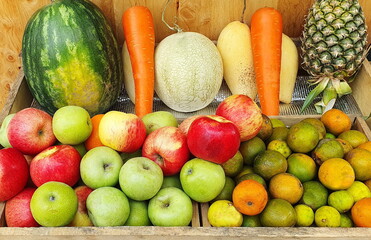 Fruits in a juice shop include oranges, green and red apples, carrots, watermelon, cantaloupe, mango, and lime. And pineapple prepared for customers to choose to make a fruit smoothie
