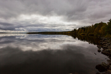 Obraz premium Dramatic autumn clouds reflection in Muonio lake, Lapland, Northern Finland