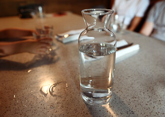 Transparent glass carafe with water on a table
