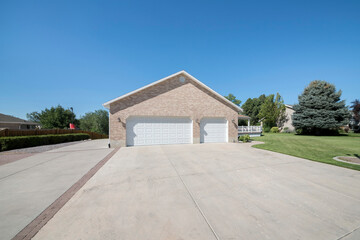 Double garage doors adjacent to each other with wall bricks and wall lamp