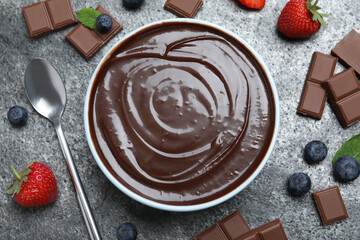 Delicious chocolate cream with berries and mint on grey table, flat lay