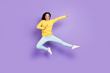 Fototapeta na wymiar Full body photo of cheerful young active woman jump up fighter good mood isolated on purple color background