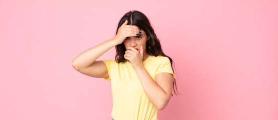young pretty woman covering face with both hands saying no to the camera! refusing pictures or...