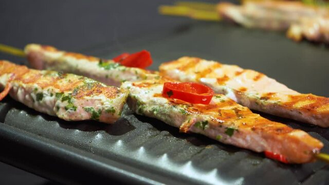 Salmon fish skewers with soy, chilli, lime sauce marinade frying with steam, 4K