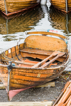 Wooden rowing boats moored up against a jetty in the Cotswolds, UK