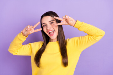 Fototapeta na wymiar Photo of cheerful young pretty positive woman hello make fingers v-signs smile isolated on purple color background