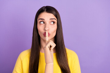 Photo of young silent brunette woman look empty space wooden finger lips isolated on purple color background