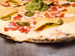 close-uo-p of a pizza with nachos and avocado dip