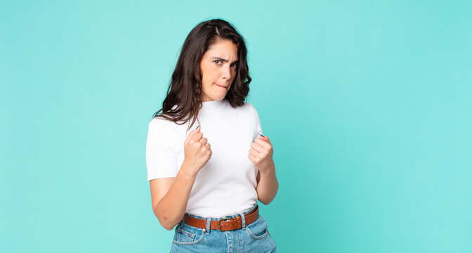 young pretty woman looking confident, angry, strong and aggressive, with fists ready to fight in boxing position