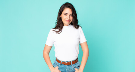 young pretty woman smiling cheerfully and casually with a positive, happy, confident and relaxed expression