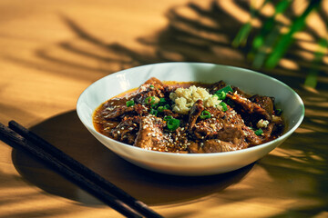 Sichuan spicy beef in a spicy sauce, garlic, pepper, sesame seeds in a white bowl. Chinese cuisine. shuizhu, shui zhu