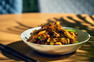 Fried eggplants in sweet and sour sauce with peppers and tomatoes. Chinese recipe and cuisine