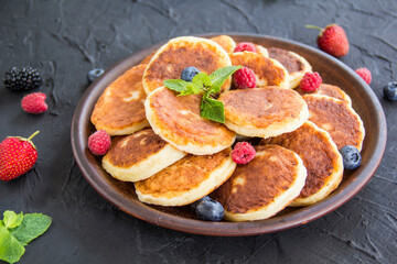 A healthy breakfast of cheese pancakes, berries, and honey. Creative atmospheric decoration