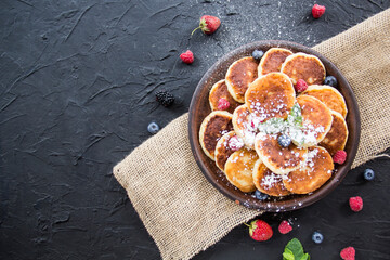 A healthy breakfast of cheese pancakes, berries, and honey. Creative atmospheric decoration